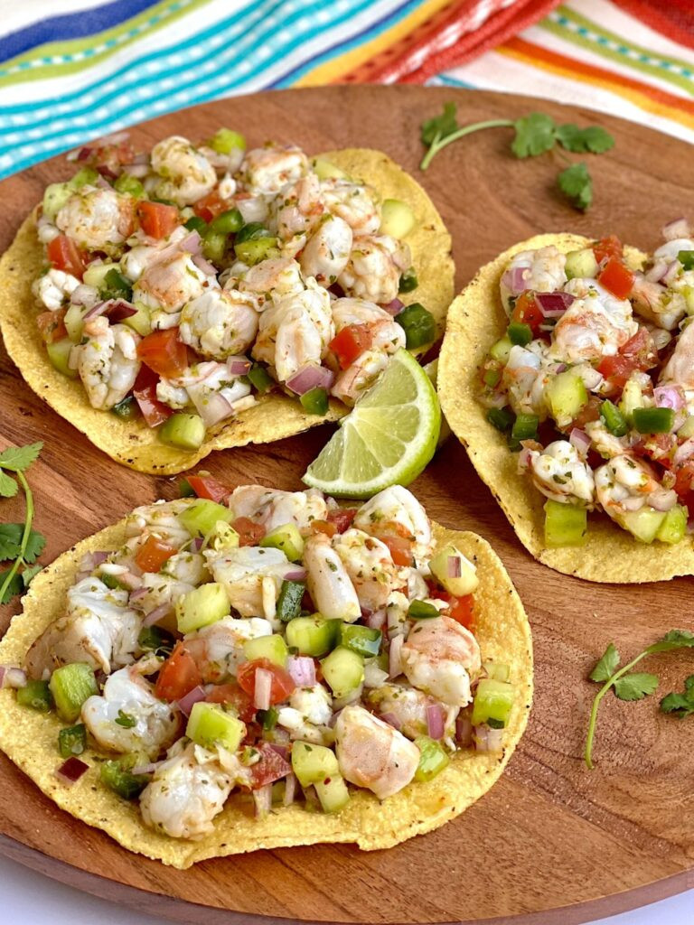 Close-up shot of vibrant Mexican shrimp ceviche with visible shrimp, cucumber, red onion, and cilantro