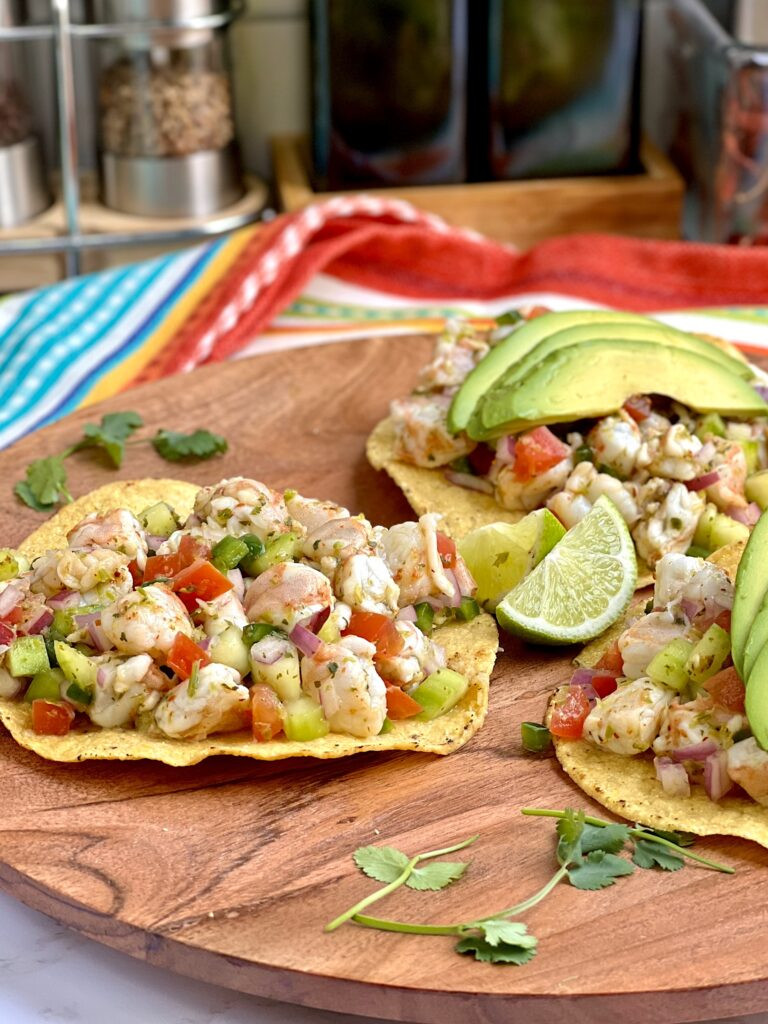 Serving suggestion for Mexican Shrimp Ceviche with tostadas, avocado slices, and hot sauce, showcasing different ways to enjoy the dish.