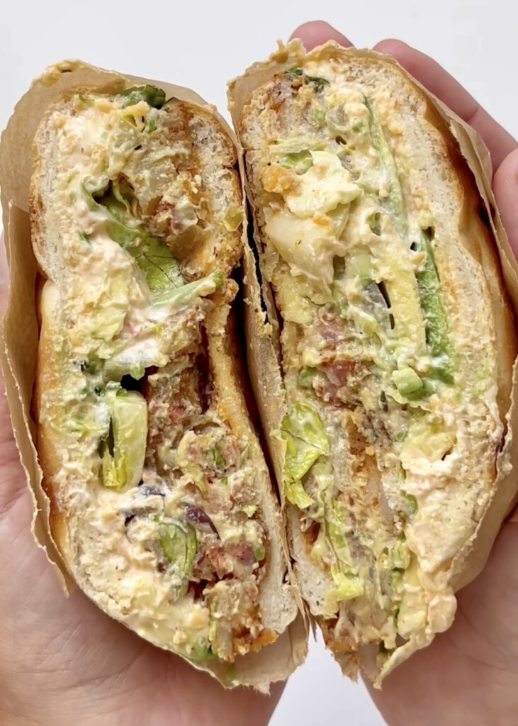 Close-up of a Mexican Pambazo Sandwich showcasing its vibrant filling and sauce-dipped bread.