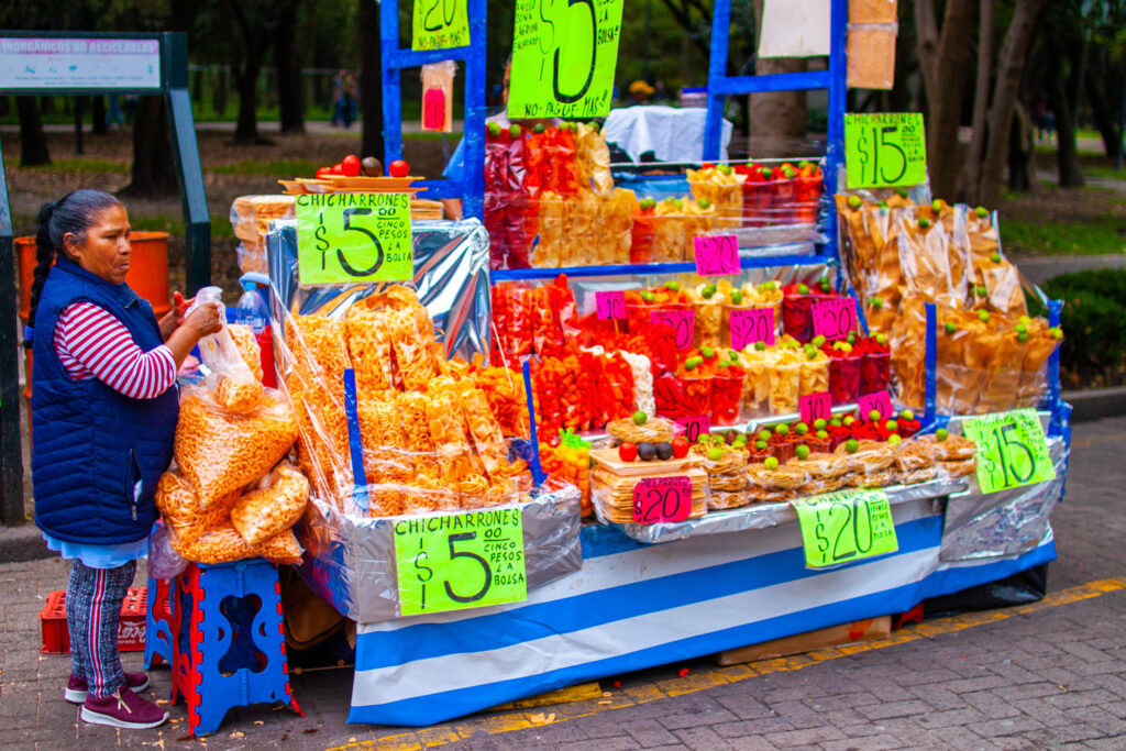 A vibrant display of fresh fruits like watermelon, mango, and pineapple, artfully arranged at a Mexican fruit vendor's cart.