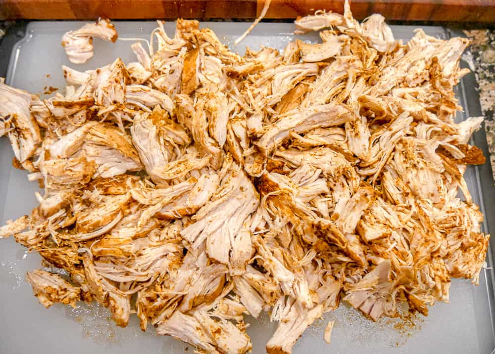 Shredded chicken breast on a cutting board ready to be used