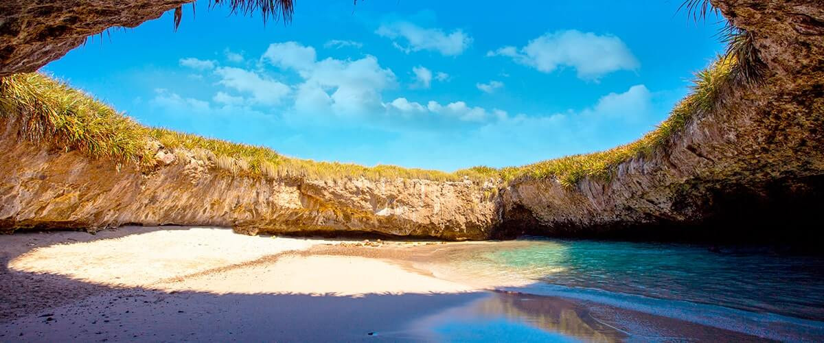 Tourists swimming towards the entrance of the Hidden Beach tunnel in Marietas Islands