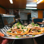 A plate of tacos inside a Mexican restaurant.