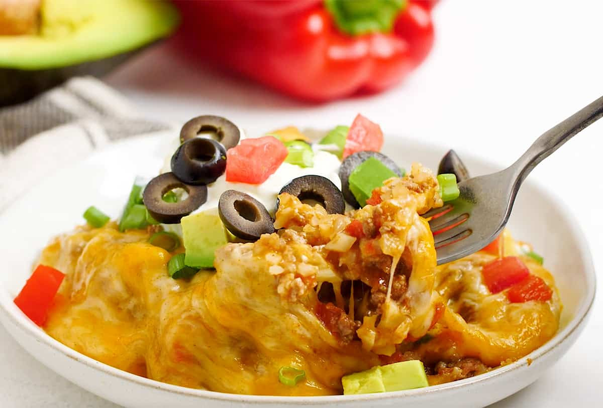 A close-up shot of a bowl of Mexican cauliflower rice with a fork.