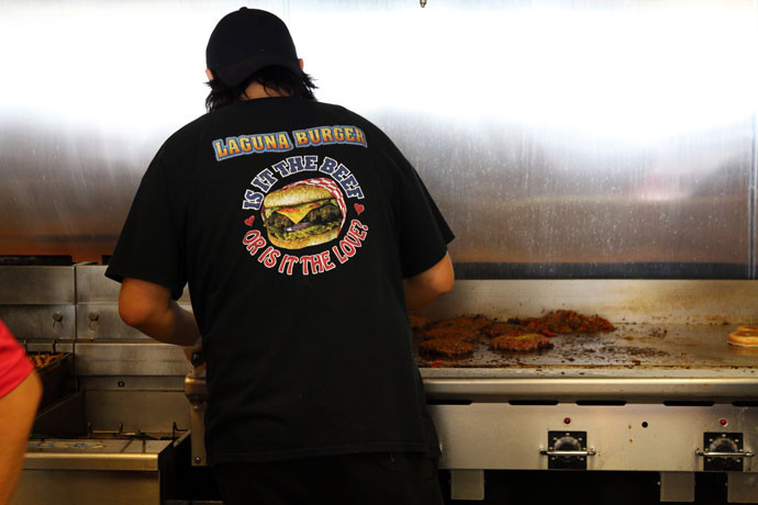 Cheromiah Marshall, Laguna Burger grill master, smiling while preparing burgers, highlighting the passion and 'love' that goes into each New Mexico Laguna Burger.