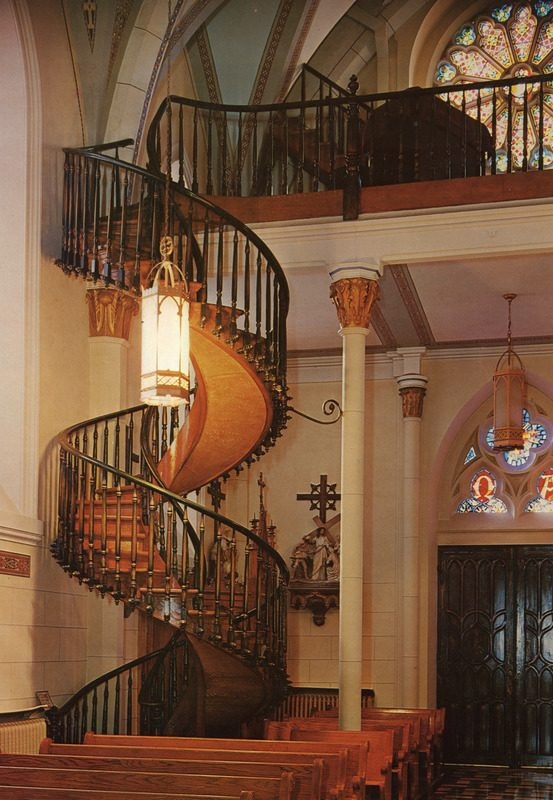 A wooden, circular staircase winds up from the back of the church to the choir loft.