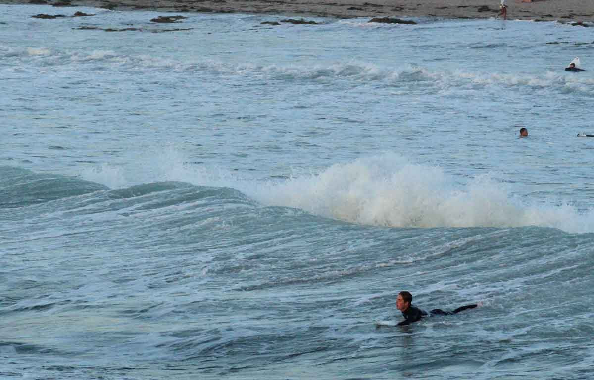 Paddling out to the lineup in Mexico, a serene image juxtaposed with the underlying concerns about safety and cartel presence often associated with surfing in Mexico.