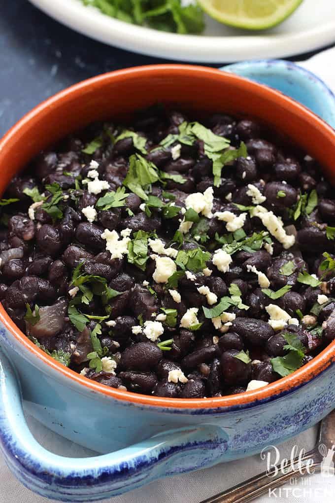 A delicious bowl of Mexican black beans topped with cotija cheese, showcasing a classic and flavorful side dish.