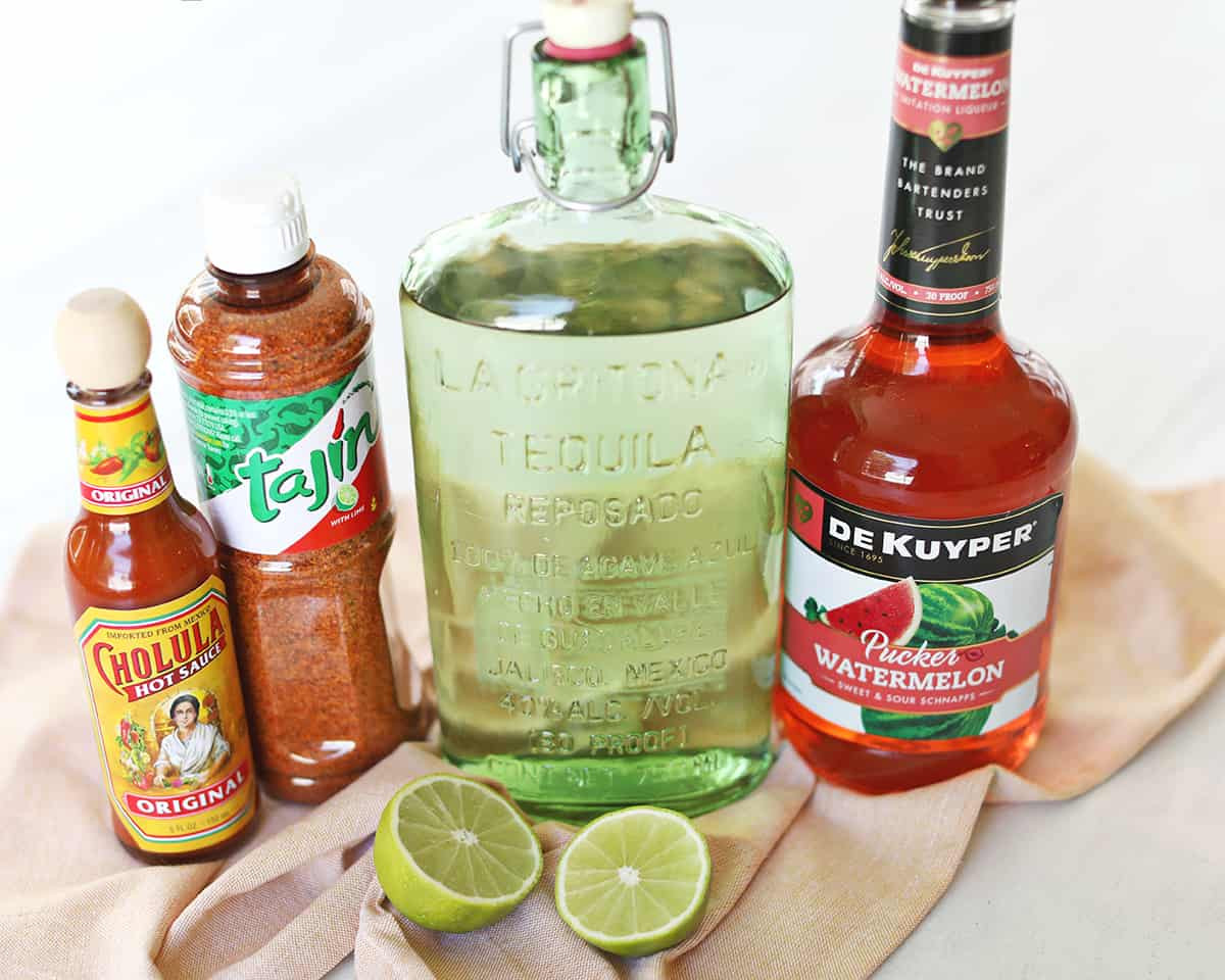 Mexican Candy Shot ingredients including tequila, watermelon pucker, lime, Tajin and hot sauce