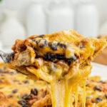 A slice of cheesy mexican chicken casserole on a plate, showcasing the layered ingredients