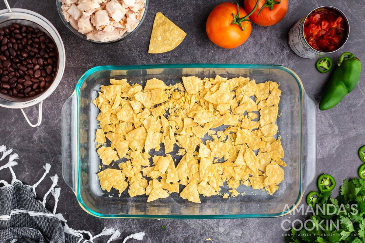 crushed tortilla chips in bottom of casserole dish