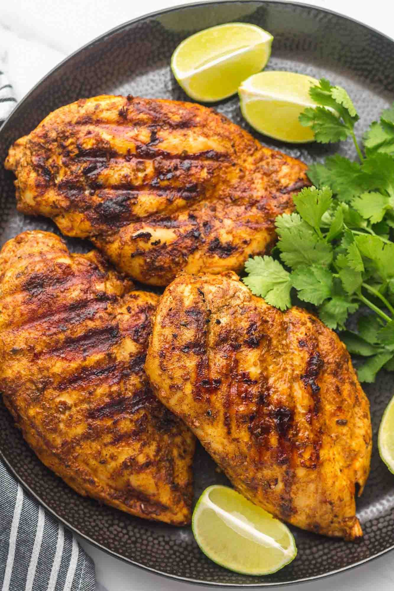 Delicious Mexican Marinade Chicken Recipe: Grilled chicken garnished with cilantro and lime wedges