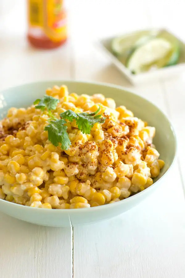 Elote, grilled Mexican street corn, being prepared.