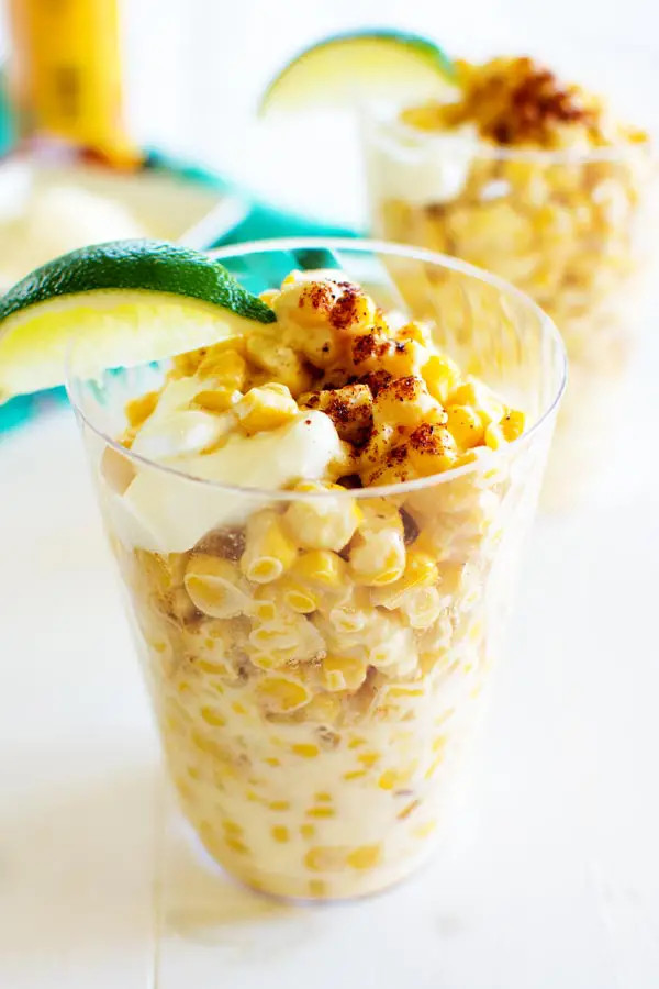 A close-up shot of esquites, Mexican corn in a cup.