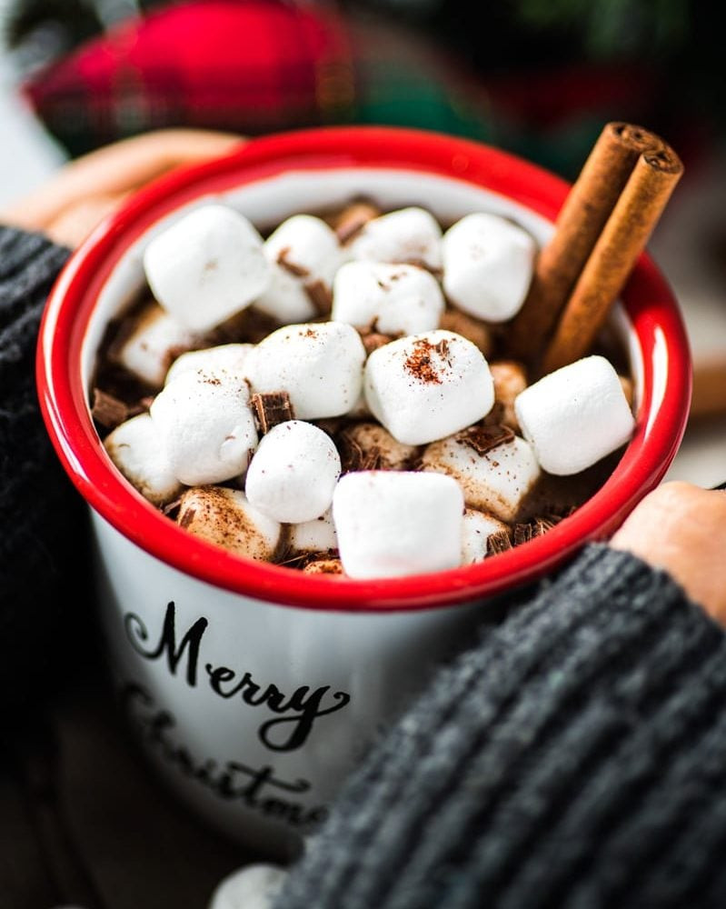 Delicious Mexican chocolate hot drink in a white mug, garnished with marshmallows and chocolate shavings, showcasing its rich and spiced flavor.