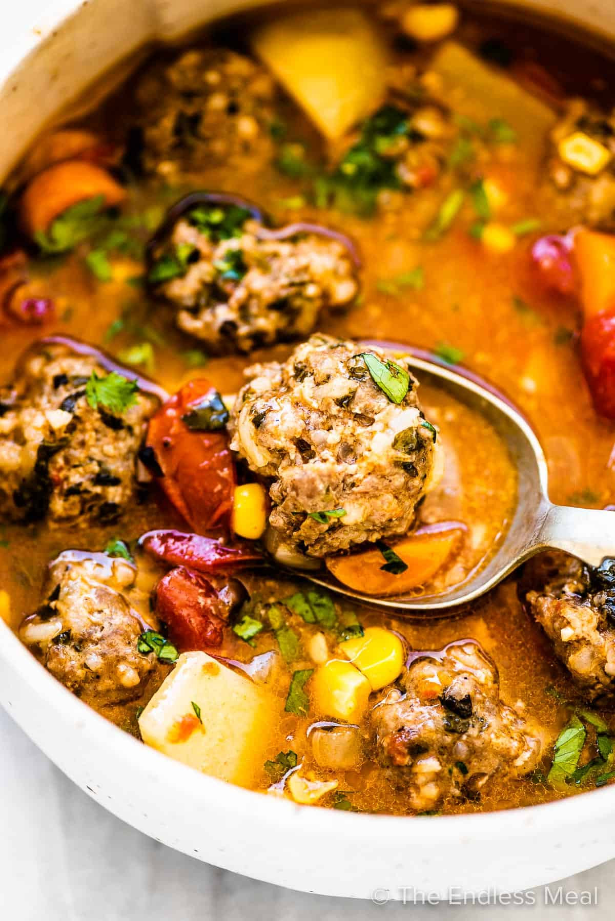 Mexican Meatball Soup (Albondigas Soup) in a white bowl with a spoon.