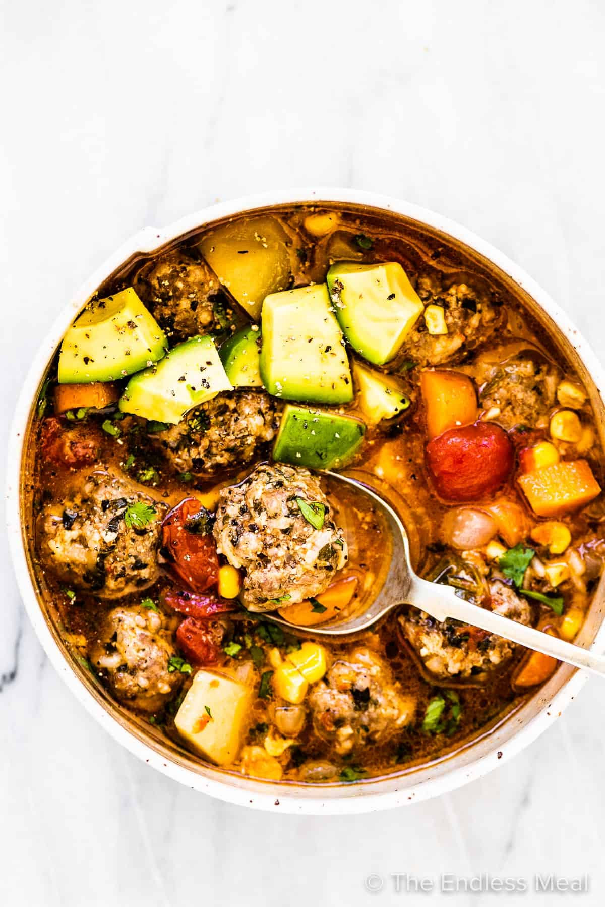 Abo bowl of sopa de albondigas (mexican meatball soup!) with diced avocado.