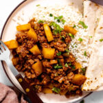 Plate of Mexican Picadillo with rice and a flour tortilla.