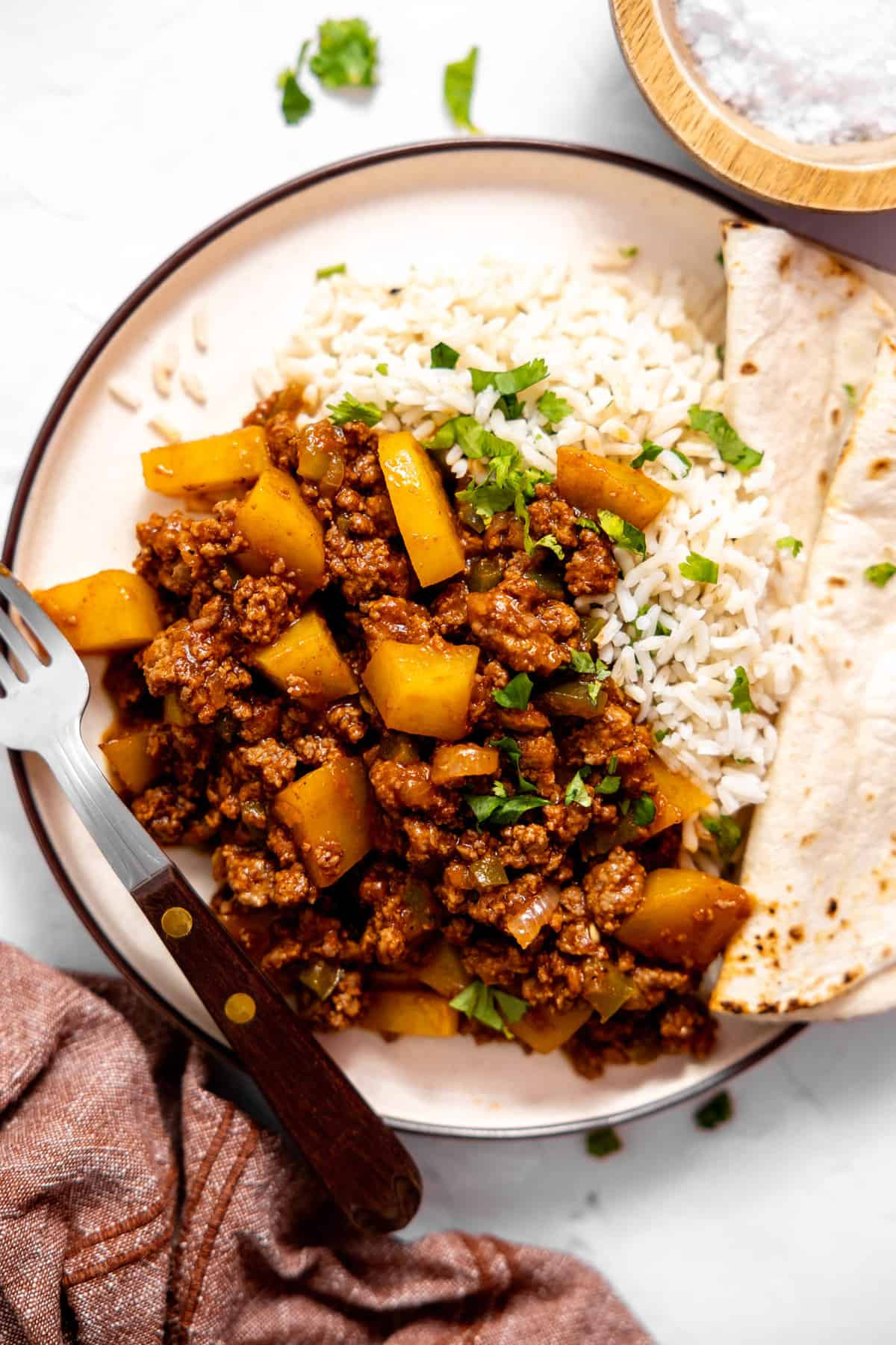 Plate of Mexican Picadillo with rice and a flour tortilla.