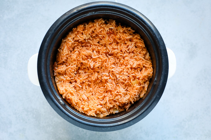 Rice cooking in a rice cooker, steam visible, highlighting the ease of cooking process