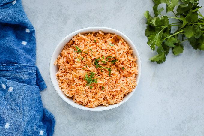 Delicious Mexican rice made in a rice cooker, served in a bowl, showcasing fluffy texture and vibrant color.