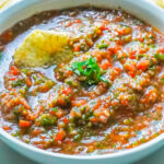 A close up picture of the finished Mexican Salsa in a white serving bowl garnished with cilantro.
