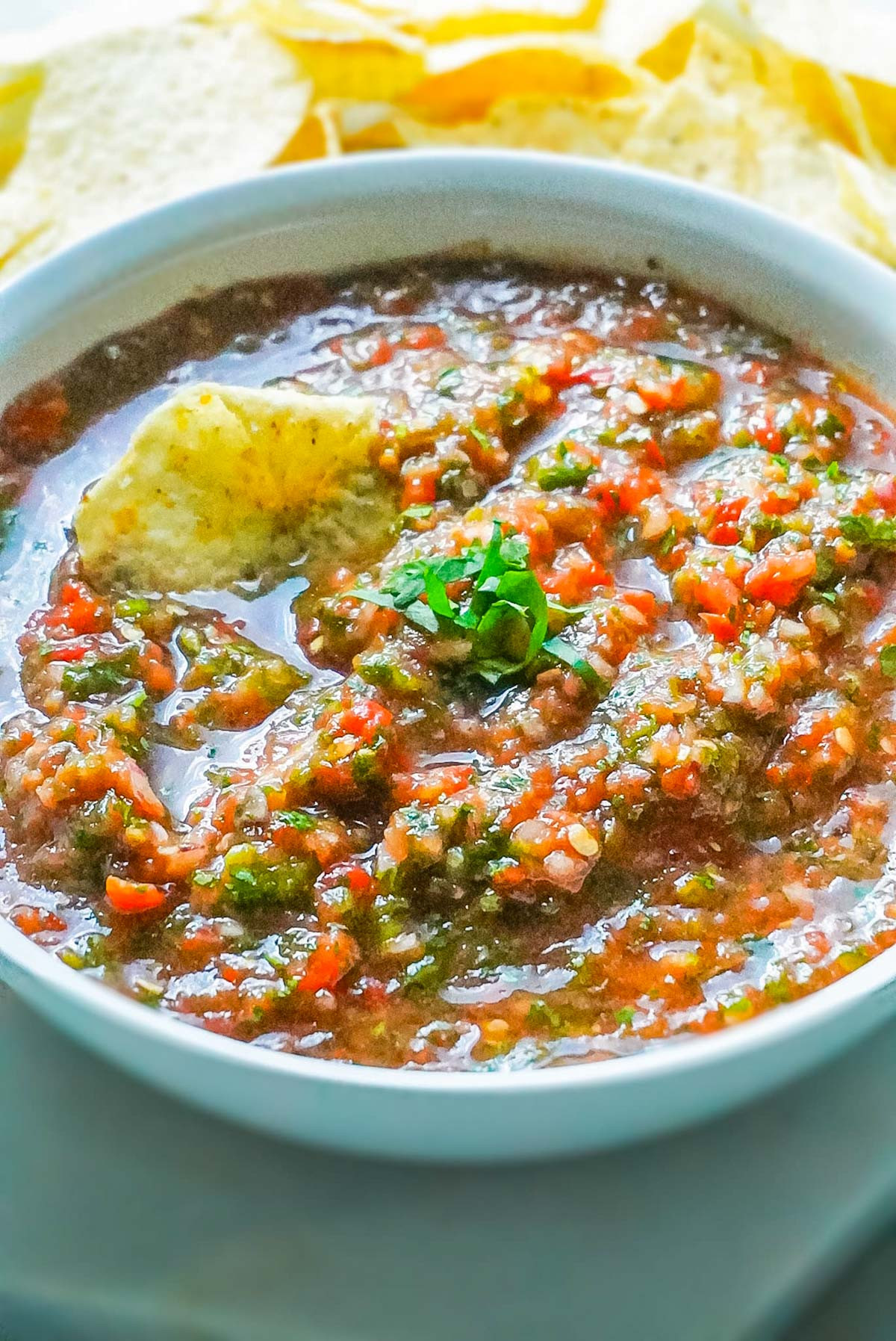 A close up picture of the finished Mexican Salsa in a white serving bowl garnished with cilantro.
