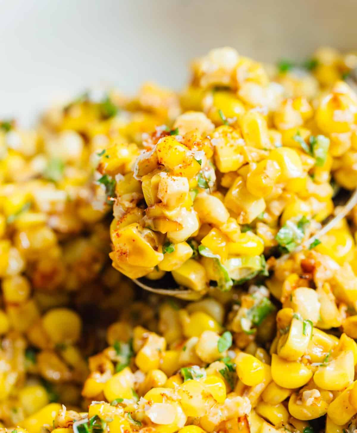 A serving suggestion image showing Mexican street corn off the cob alongside grilled shrimp skewers and lime wedges.