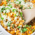 Close up image of Mexican street corn topped with cotija and cilantro.