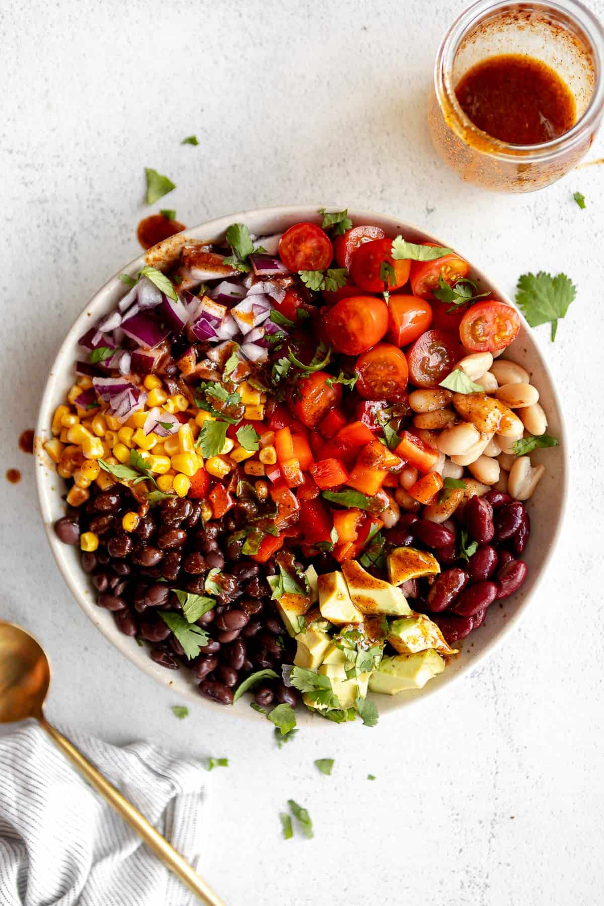 A vibrant bowl of Mexican bean salad, topped with fresh cilantro, showcasing the colorful and appetizing dish