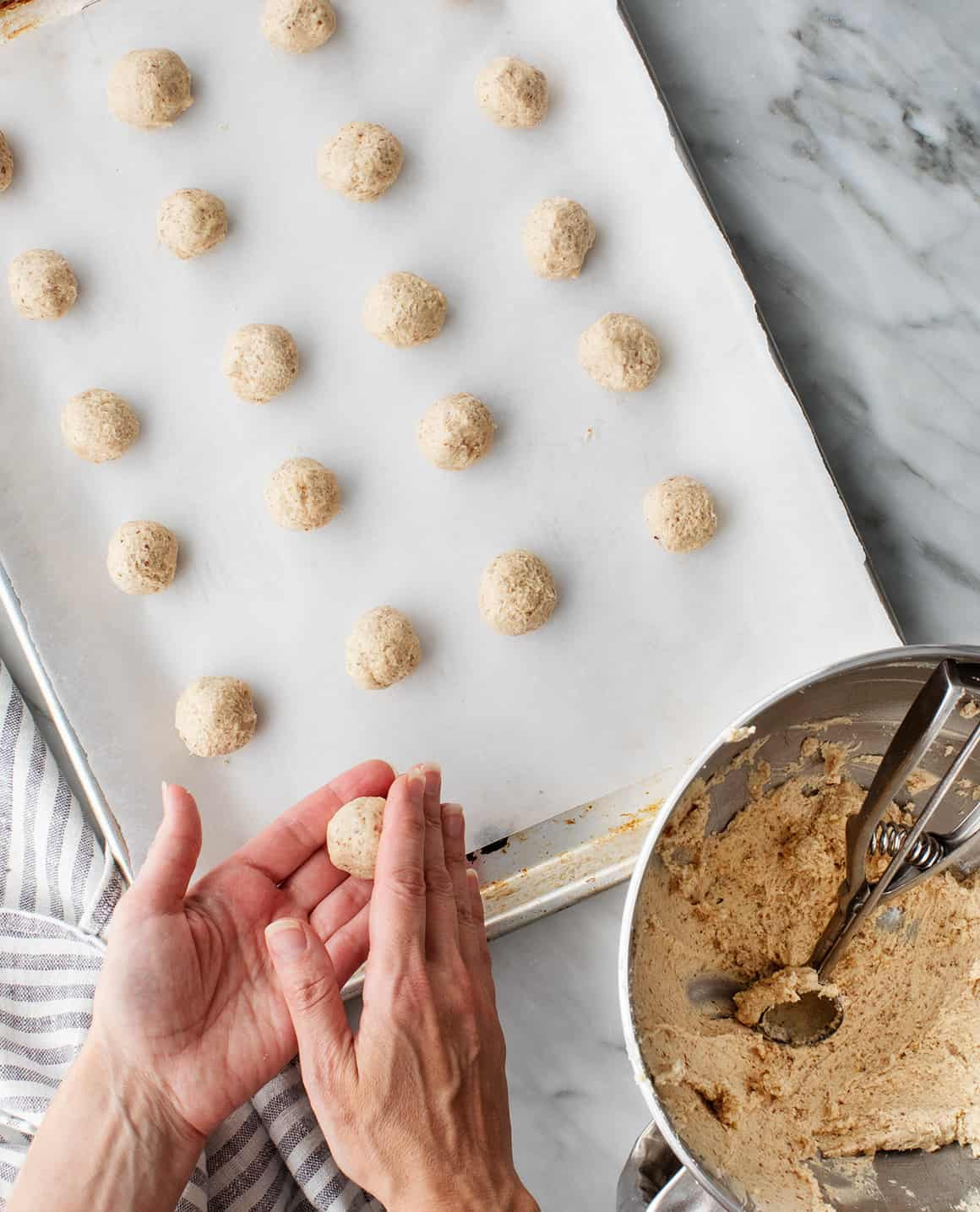 Hands rolling cookie dough into balls