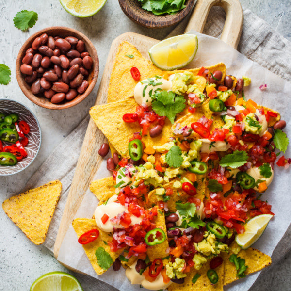 Nachos served as appetizers at a Mexican fiesta birthday party, a popular and customizable food option.