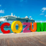 Cozumel welcome sign with cruise ships in the background