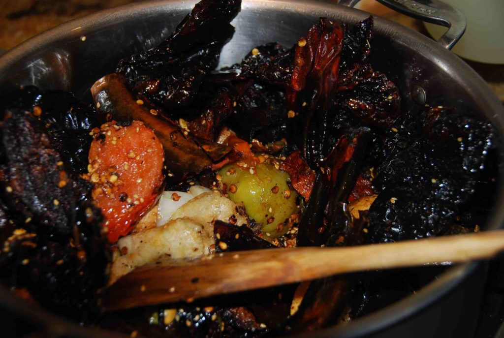 All cooked ingredients for Mole Poblano combined in a pot, ready for the next stage of simmering and flavor development.