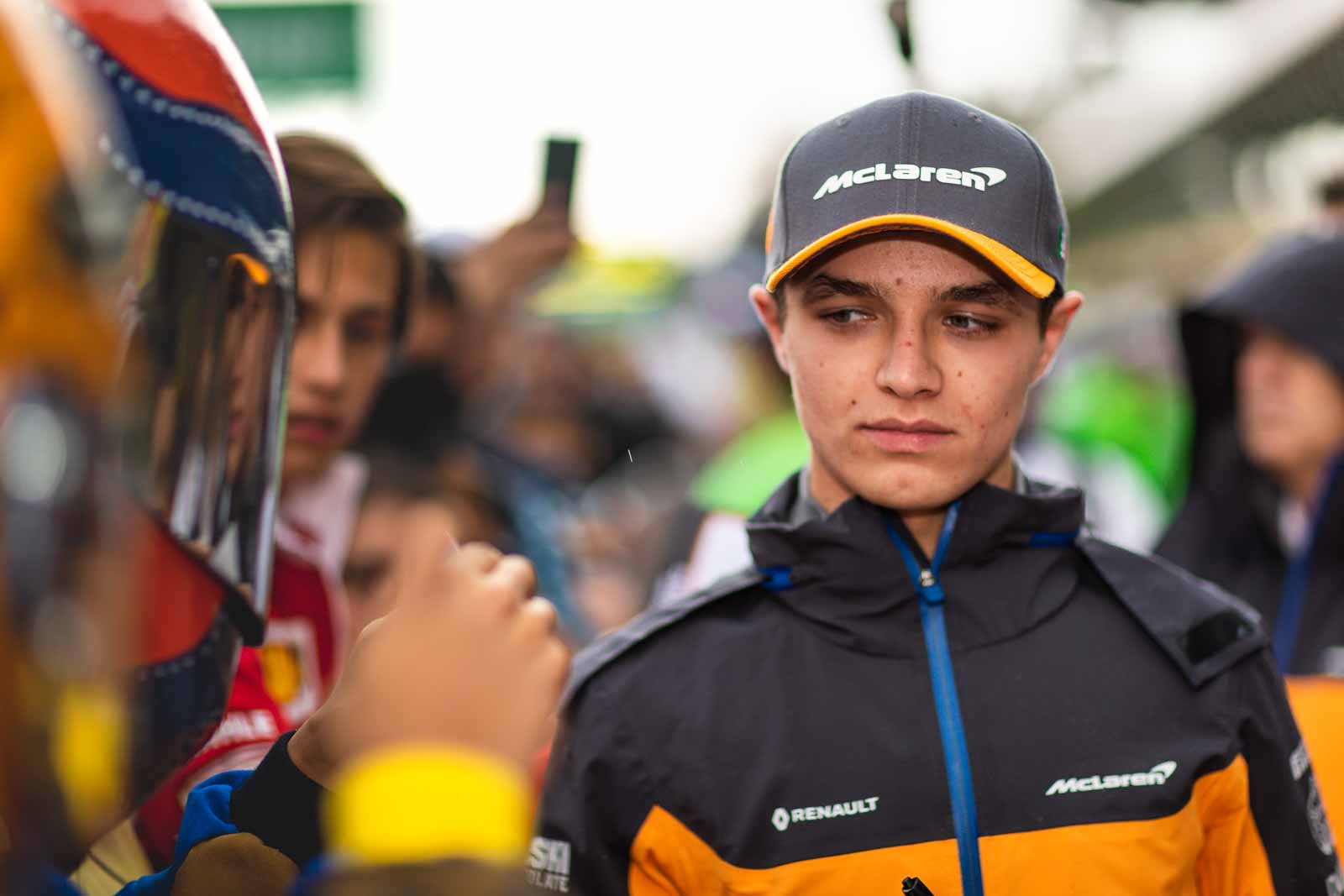 Lando Norris signs autographs while wearing a special Mexican Grand Prix McLaren cap in the pit lane