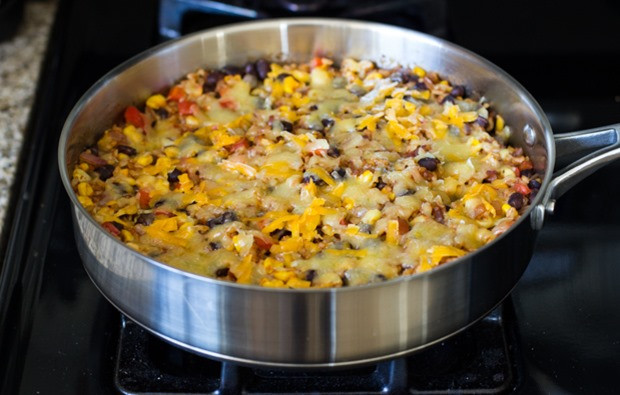 Overhead shot of all ingredients combined in the skillet before topping with cheese for Mexican Rice Casserole.
