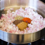 Sizzling onions and spices in a skillet, the first step to a flavorful Mexican casserole.