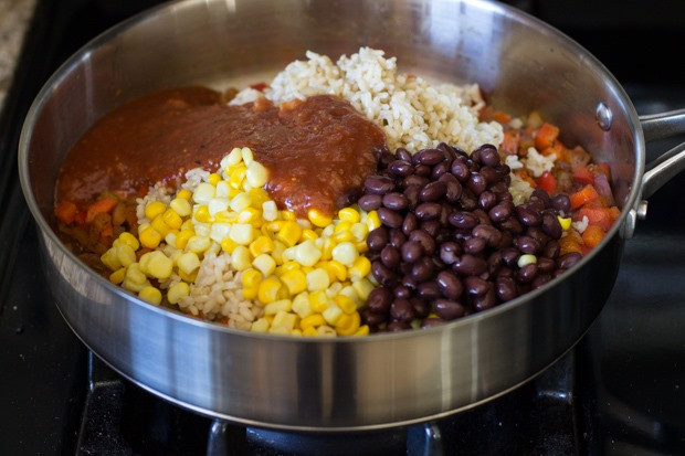 Stirring in beans, corn, brown rice, and salsa for a hearty and flavorful Mexican rice casserole.