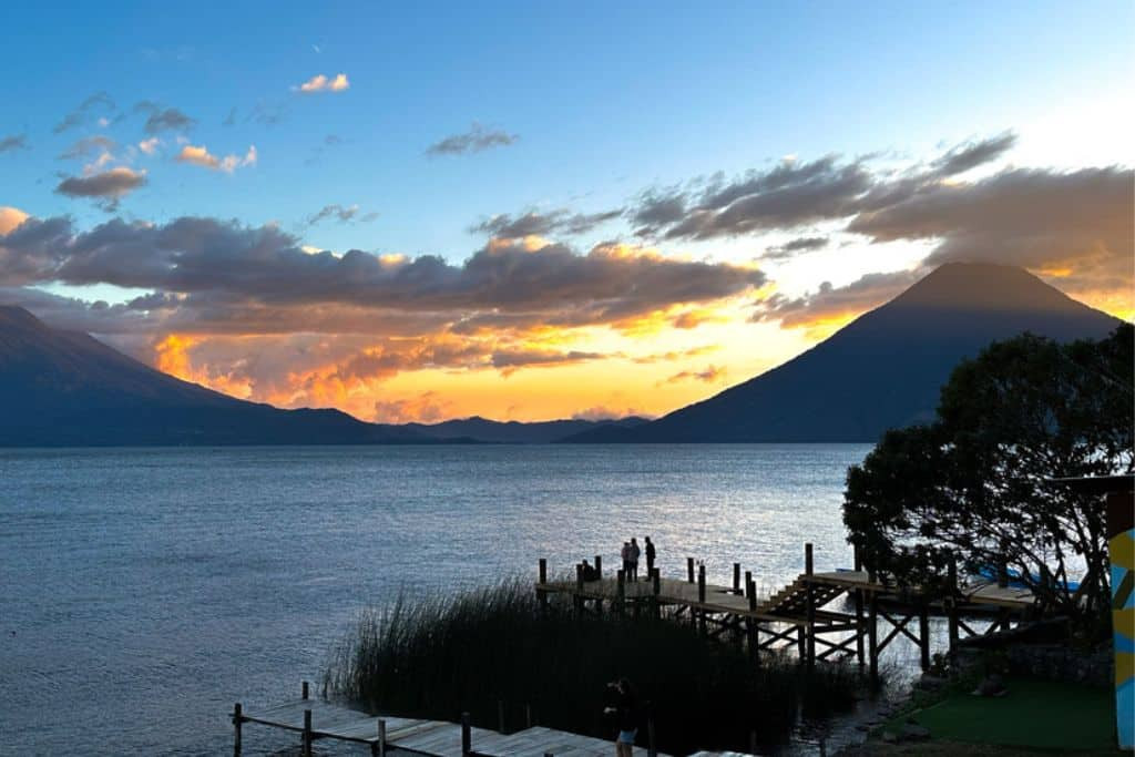 A tranquil sunset view over Lake Atitlan in Guatemala, surrounded by volcanoes