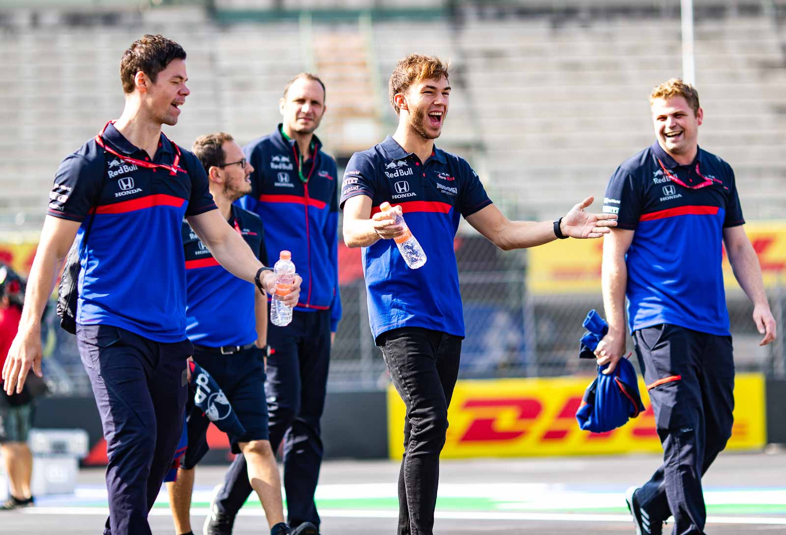 Pierre Gasly jokes with a Toro Rosso team member while walking the track at the Mexican Grand Prix