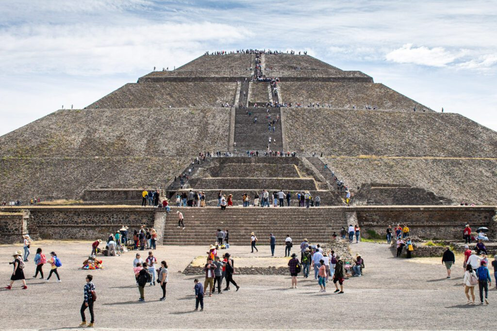 The majestic pyramids of Teotihuacan rising above the landscape under a clear sky.