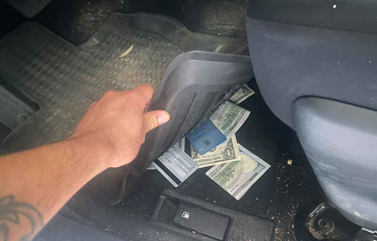 A &quot;secret stash&quot; of cash and credit cards hidden under a car mat, illustrating a tip for protecting valuables during travel in Mexico to avoid scams.