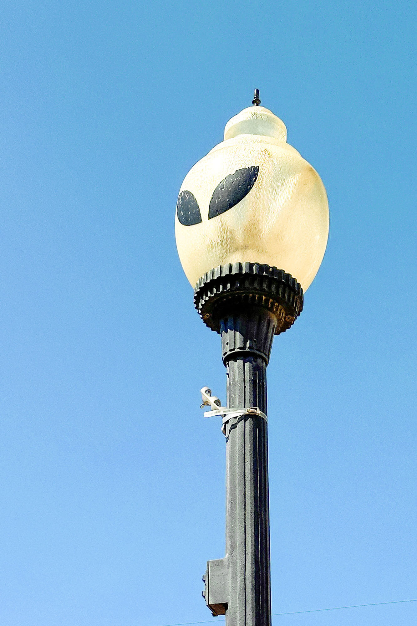 Alien face painted on a street light in Roswell, a New Mexico Road Trip destination