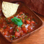 Freshly made Mexican salsa recipe for canning, vibrant red color and chunky texture.