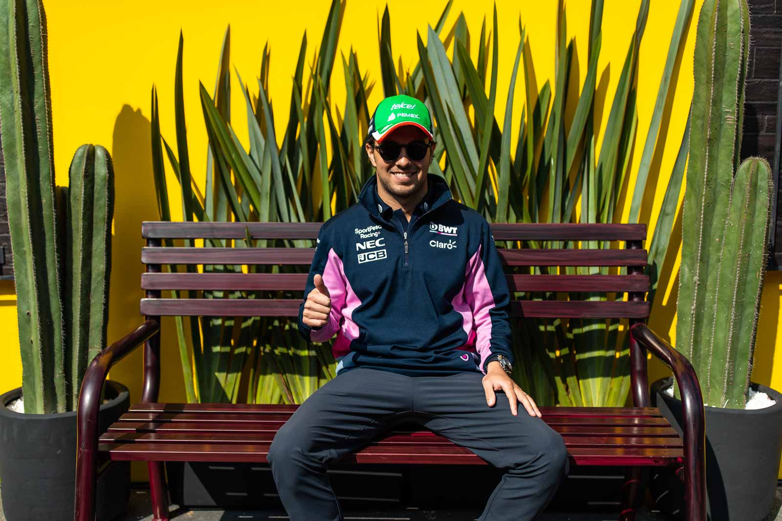 Sergio Perez, the Mexican Formula 1 driver, poses for photos on a bench in the paddock during the Mexican Grand Prix