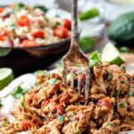 Shredded Mexican Chicken on a wood cutting board.