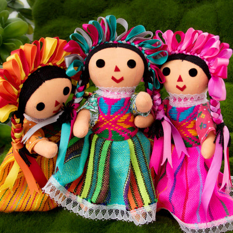 A close-up image highlighting the details of a Lelé doll's traditional clothing and braided hair