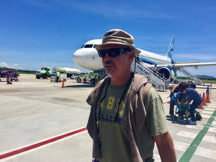 man walks across tarmac in zihuatanejo, mexico