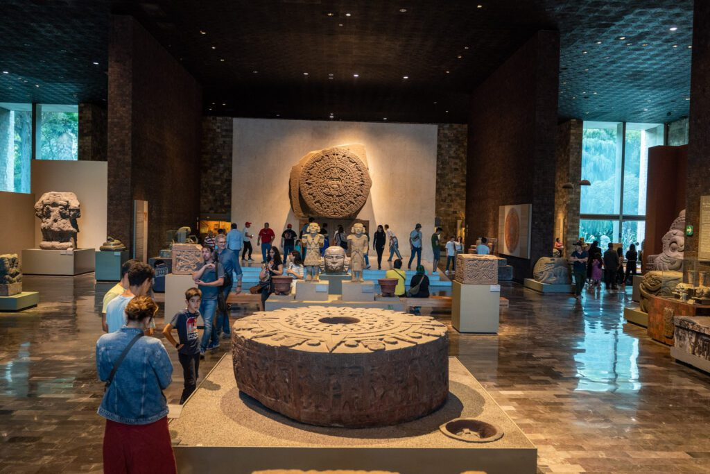 The iconic Aztec sun stone on display at the Anthropology Museum, showcasing intricate carvings.