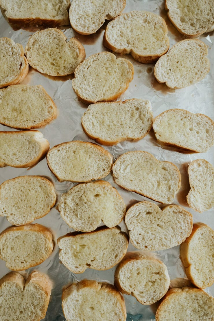 process shot - buttered bread slices on a foil-lined baking sheet. 